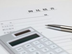 見積書の上に置かれた電卓とペン